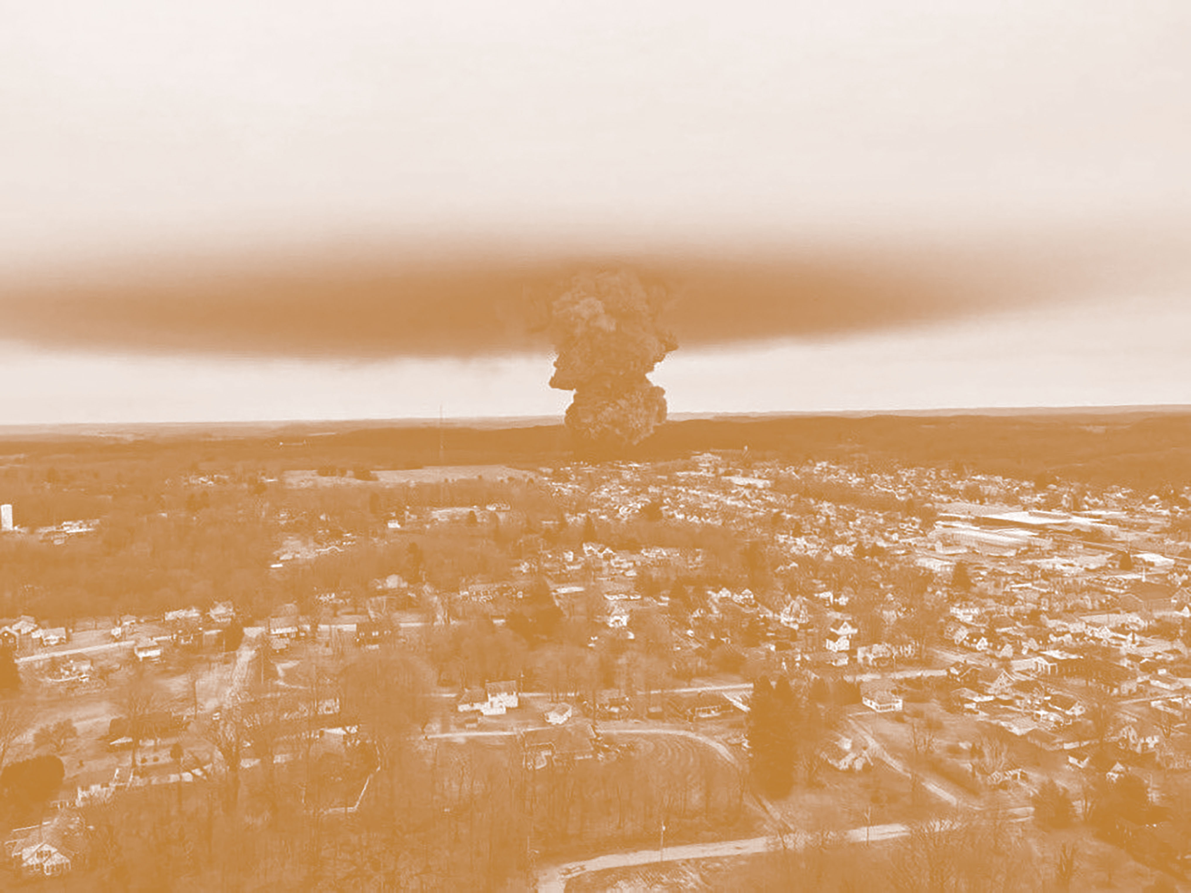Sepia image of a large black cloud of toxic chemicals as seen by a drone above the town of East Palestine, Ohio.